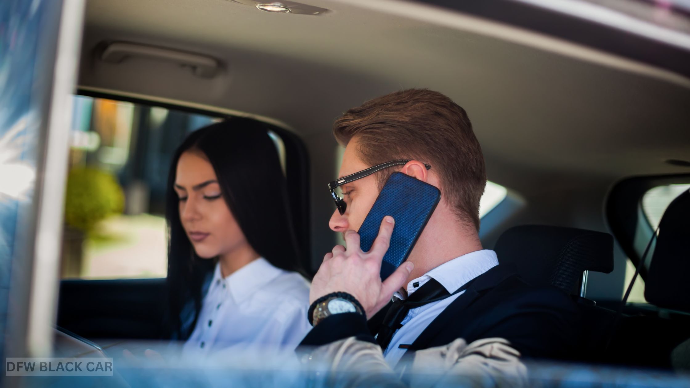 Business professionals working and reviewing documents in the backseat of a chauffeur-driven luxury car, focused on a client presentation while traveling through the city.